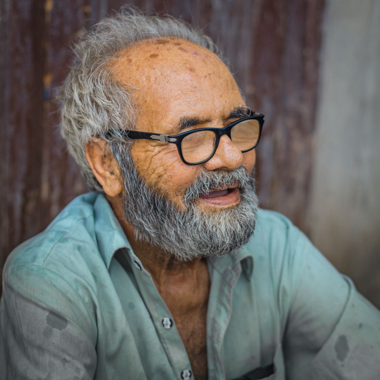 Portrait of a smiling older man with grey hair and glasses