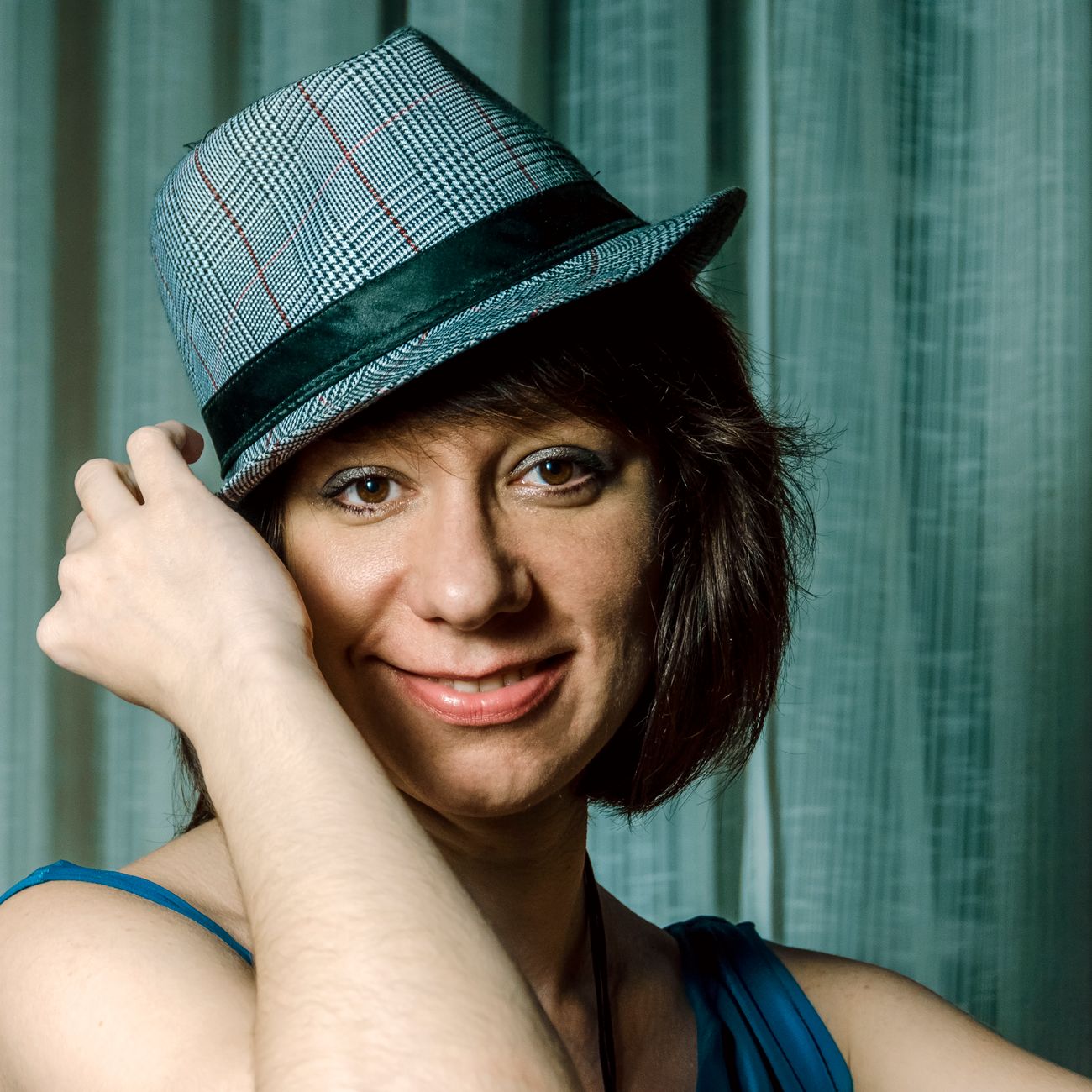 Portrait of a smiling woman wearing a blue fedora