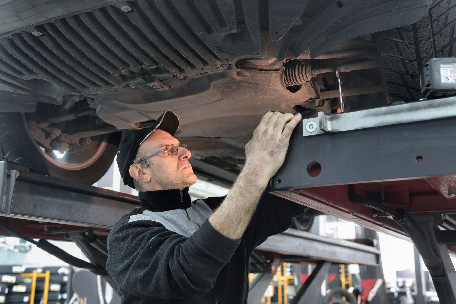 Photo of a mechanic inspecting a vehicle in a workshop