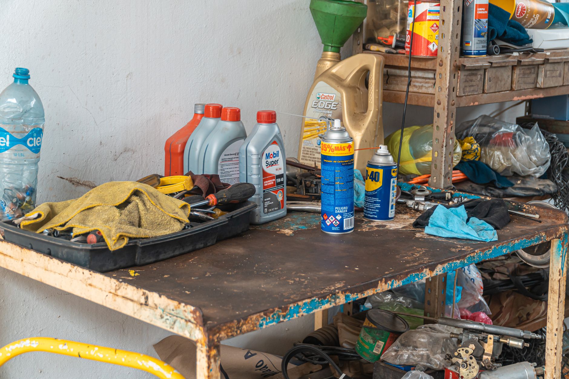 Photo of a workbench of tools and oil cans in a garage