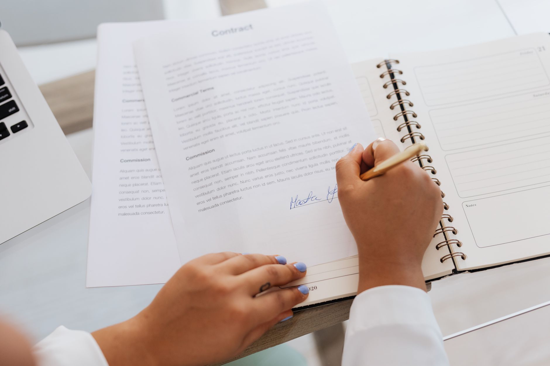 Photo of a hand signing a document with a pen, standing in for the owner's signature