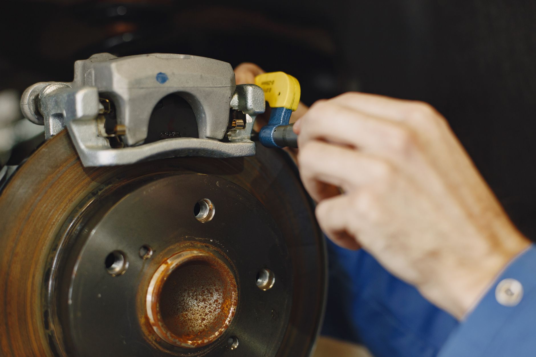 Photo of a mechanic inspecting a disc brake for wear