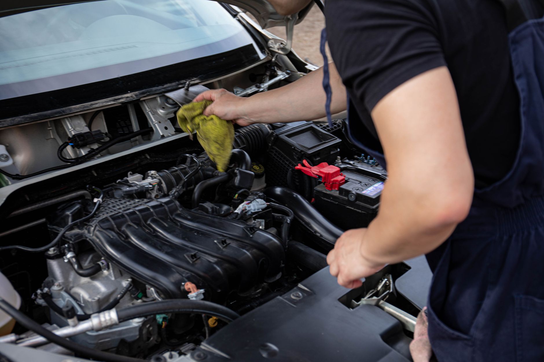 Photo of a mechanic repairing and cleaning a car engine