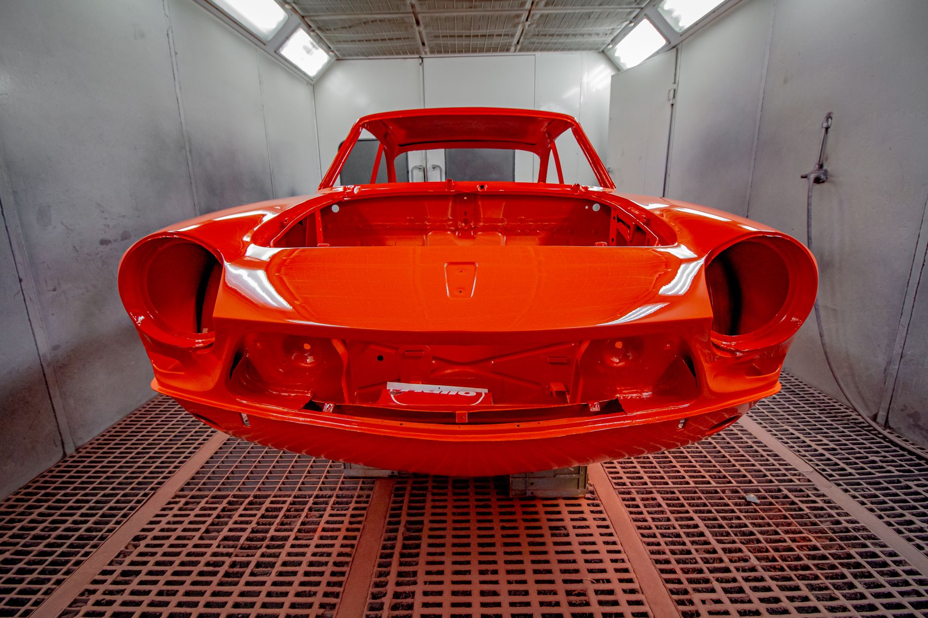 A freshly painted car body in the spray booth