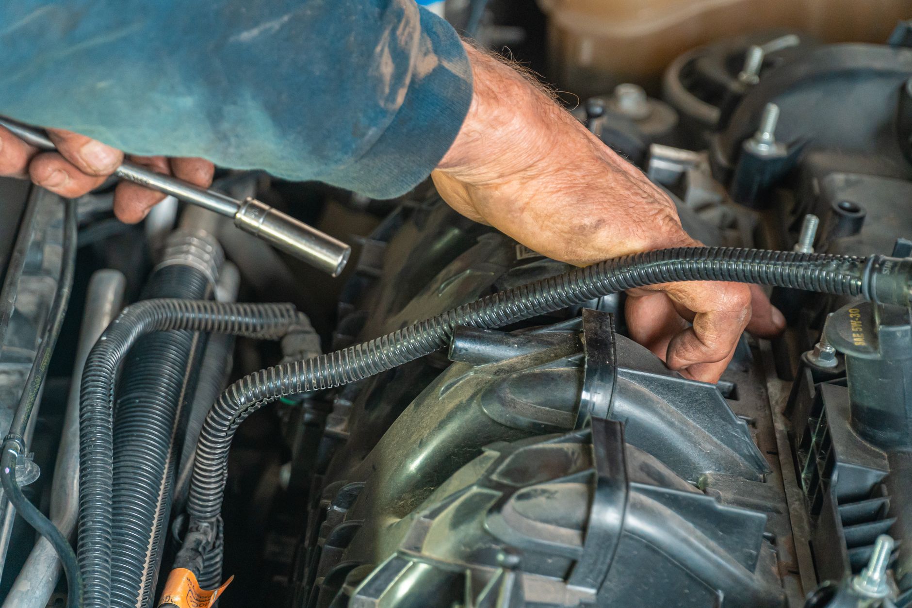A mechanic working on a car engine with a wrench