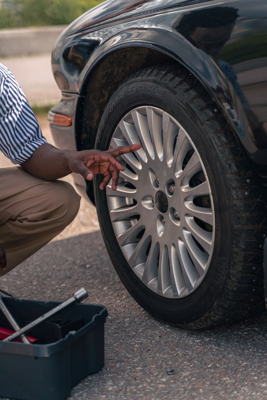 A man pointing at a car tyre during an inspection