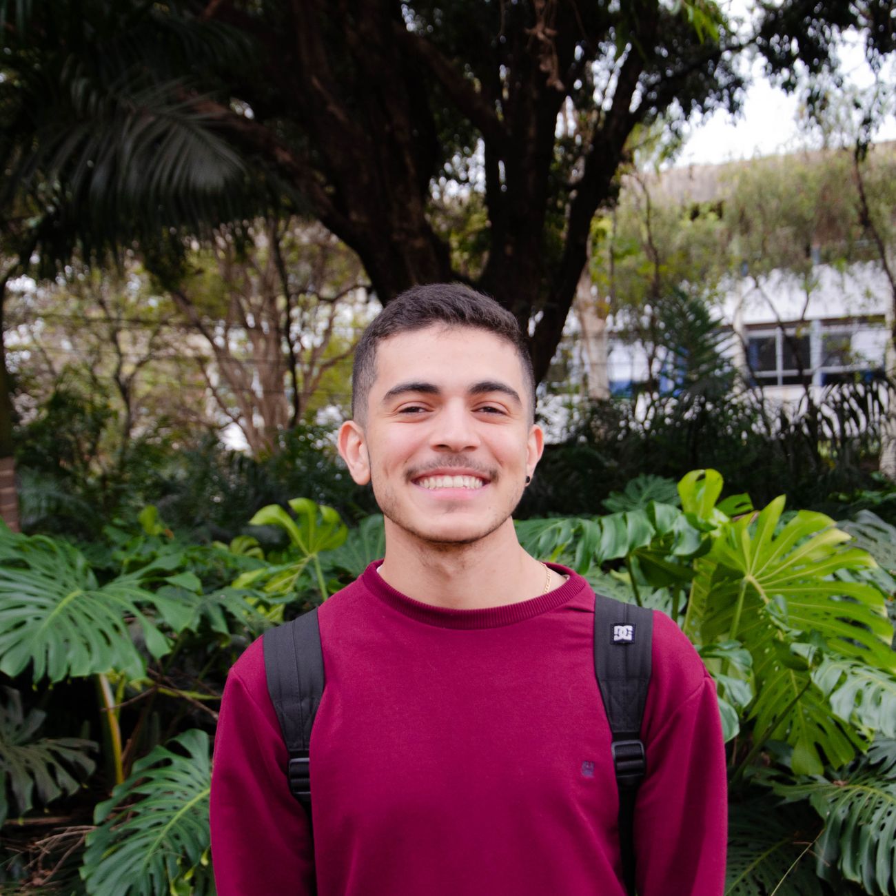 Portrait of a smiling young man in front of foliage