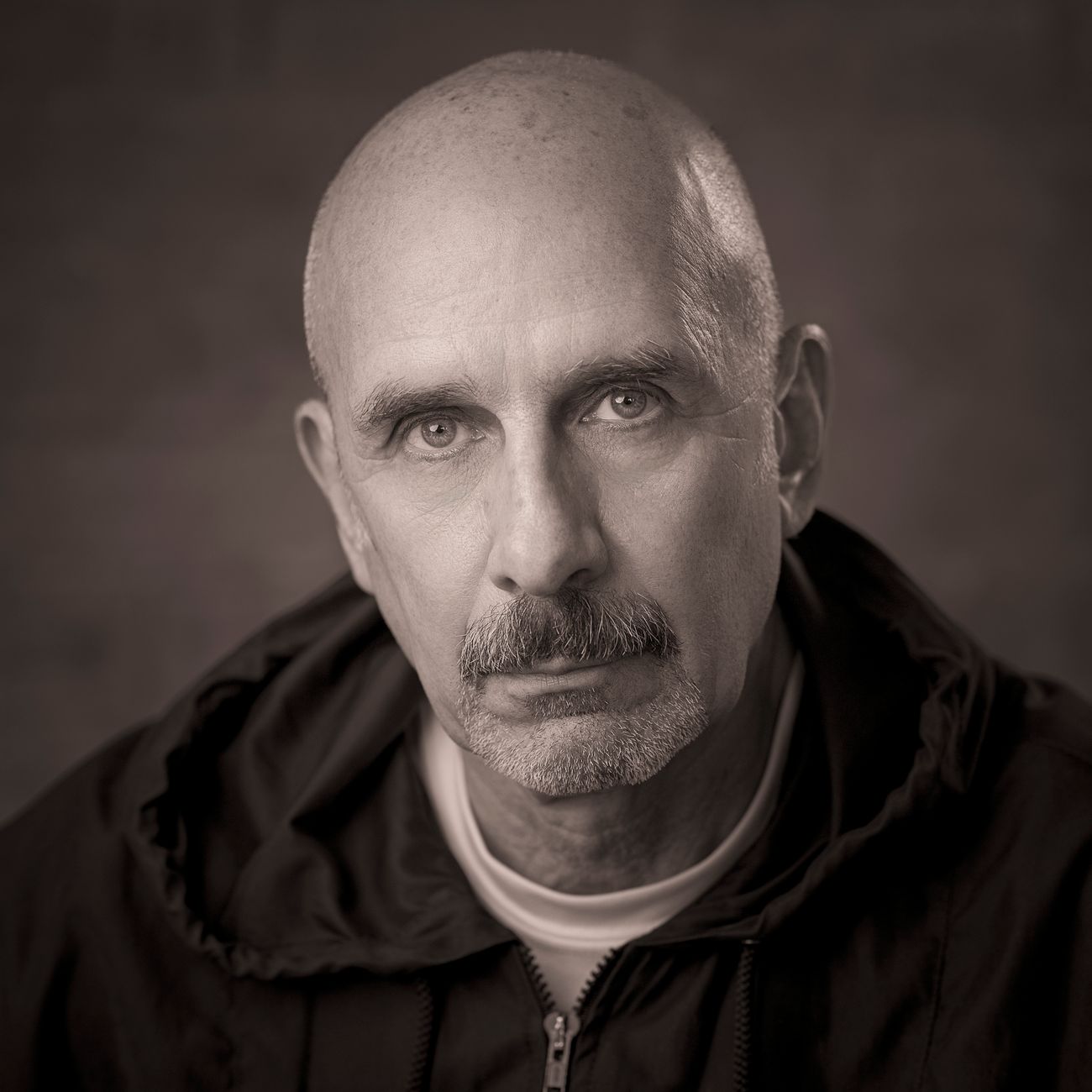 Sepia portrait of a bald man with a moustache