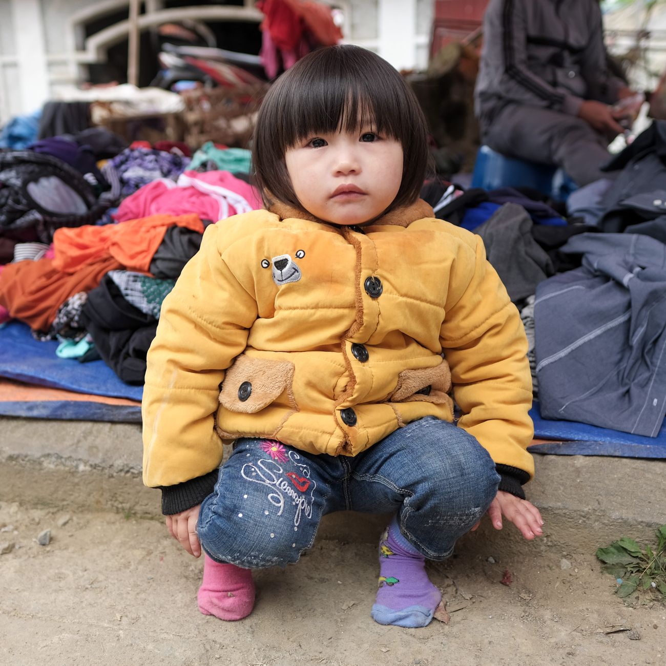 A small child in a yellow coat outdoors