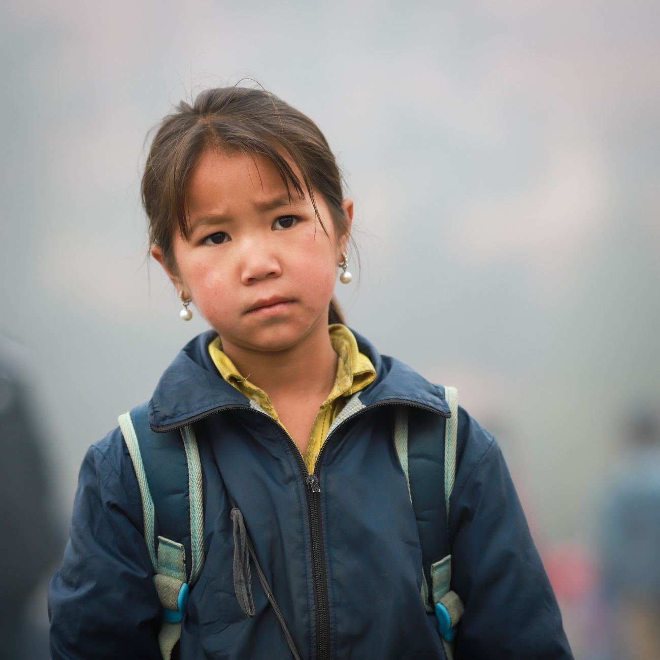 A young girl in traditional clothing standing in daylight
