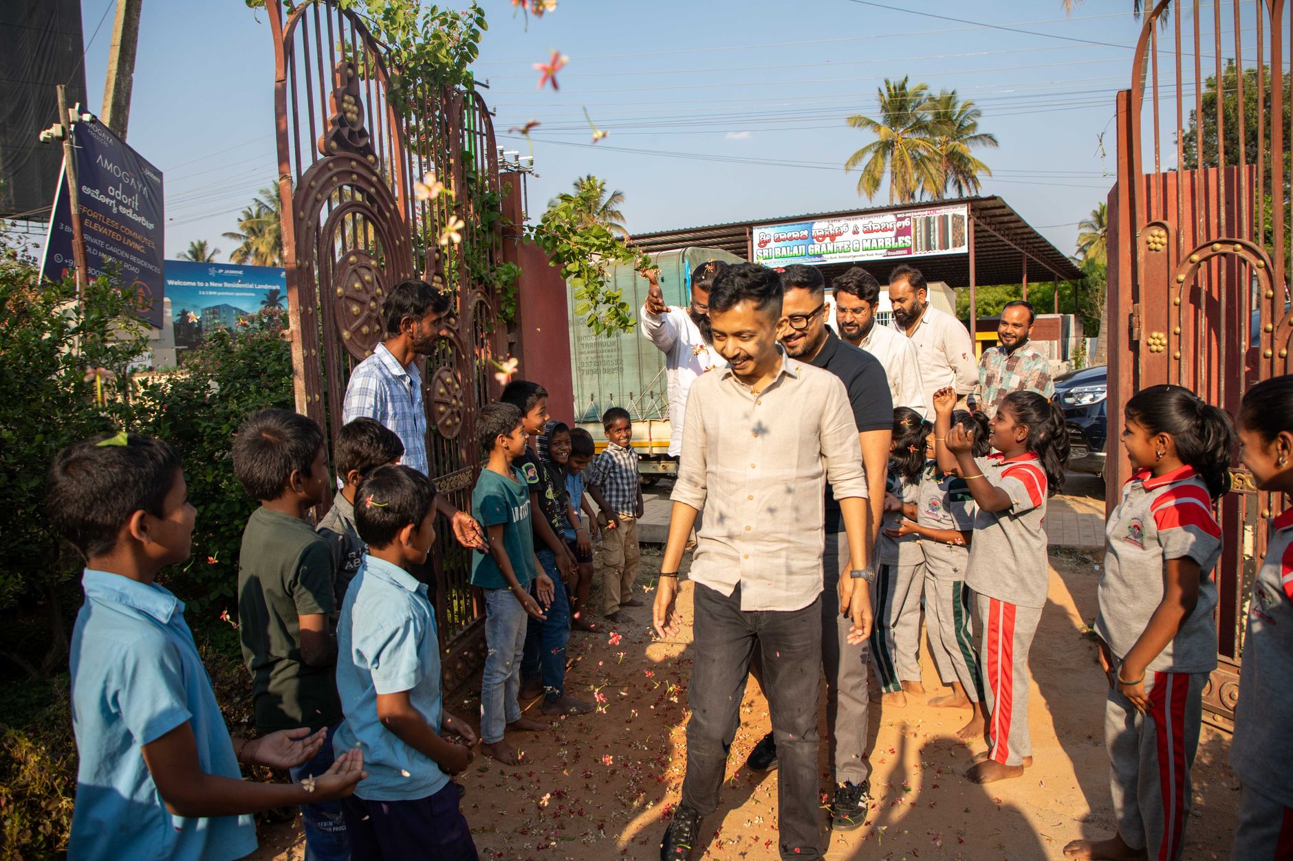 Children and adults gathered outdoors in sunny weather