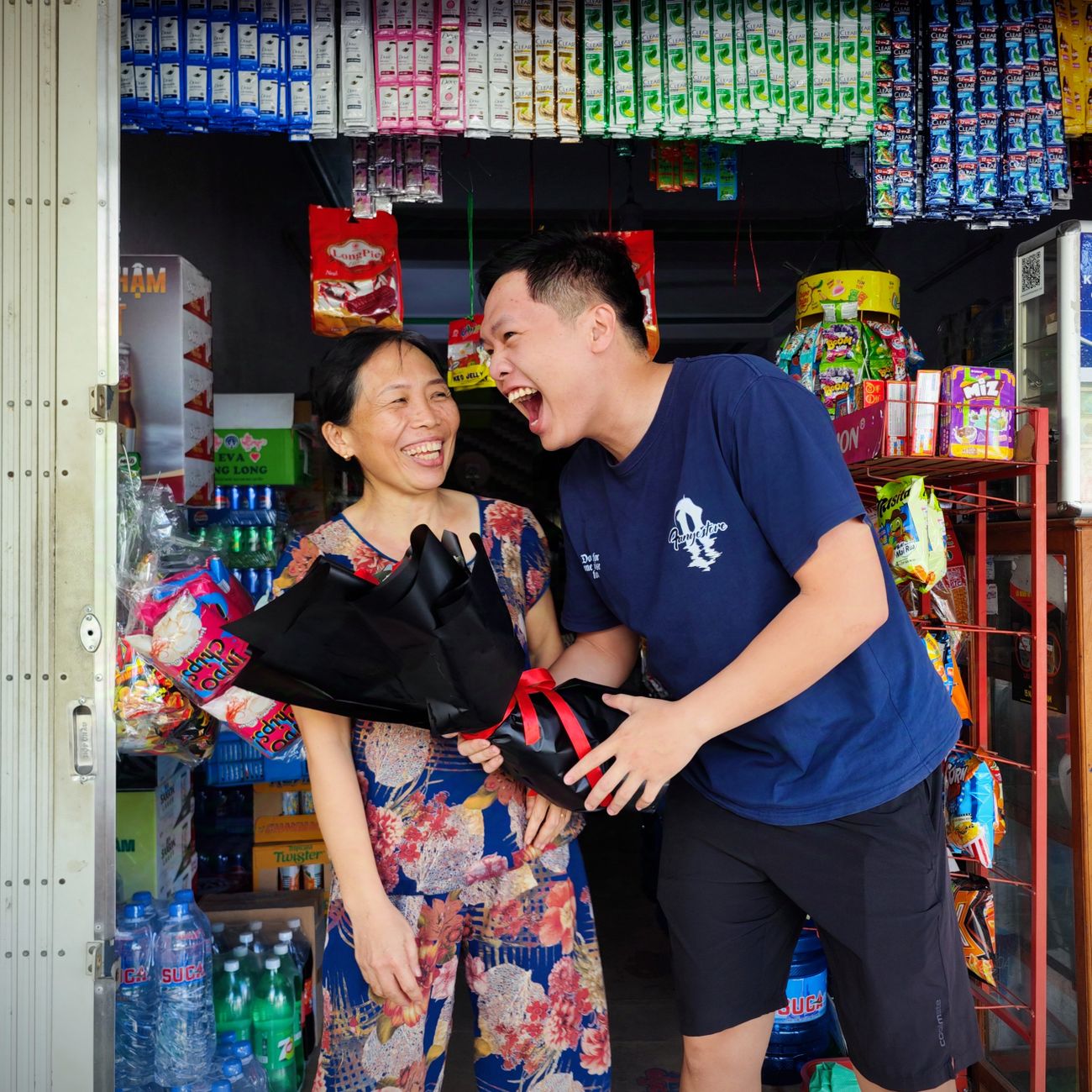 A mother and son laughing together in a shop