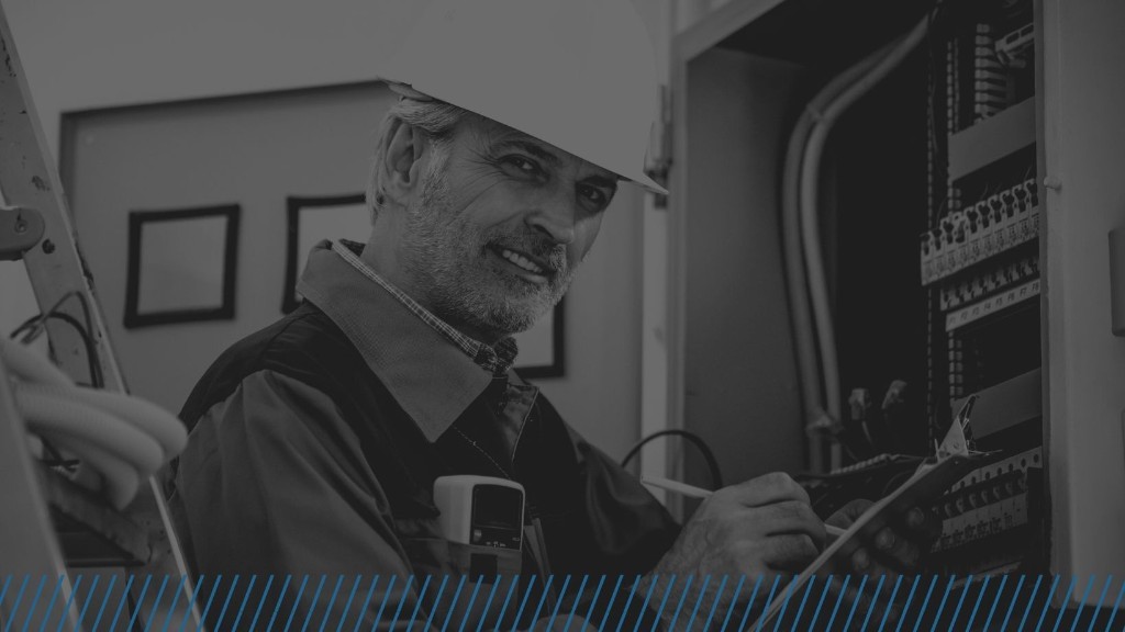 Electrician smiling while inspecting an electrical panel