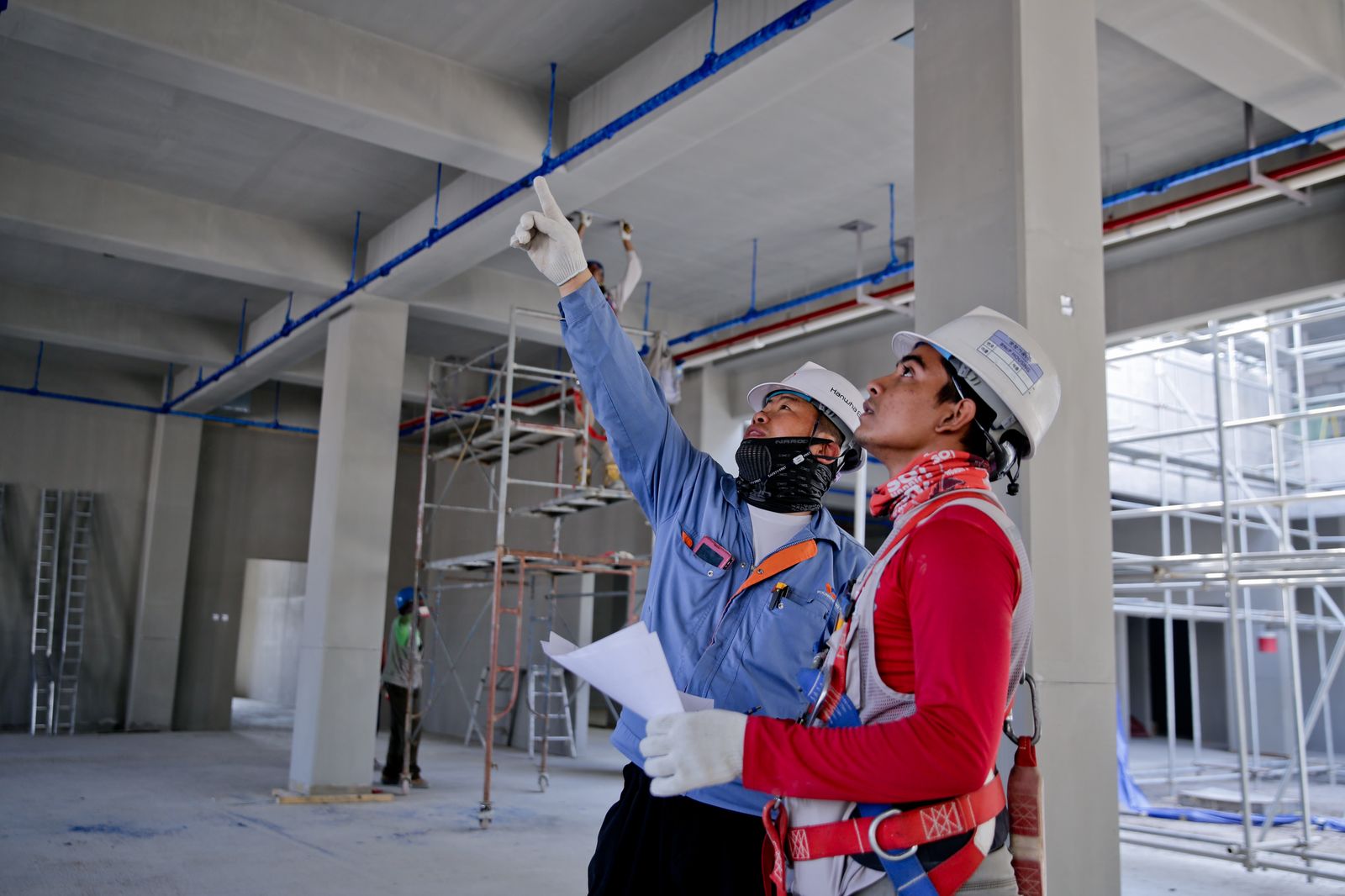 Electricians reviewing plans on a commercial construction site