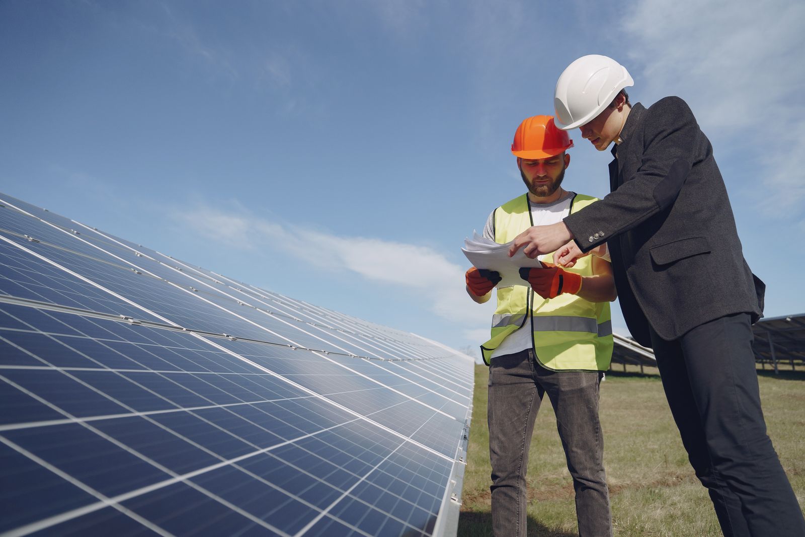 Electricians reviewing plans at a solar panel installation