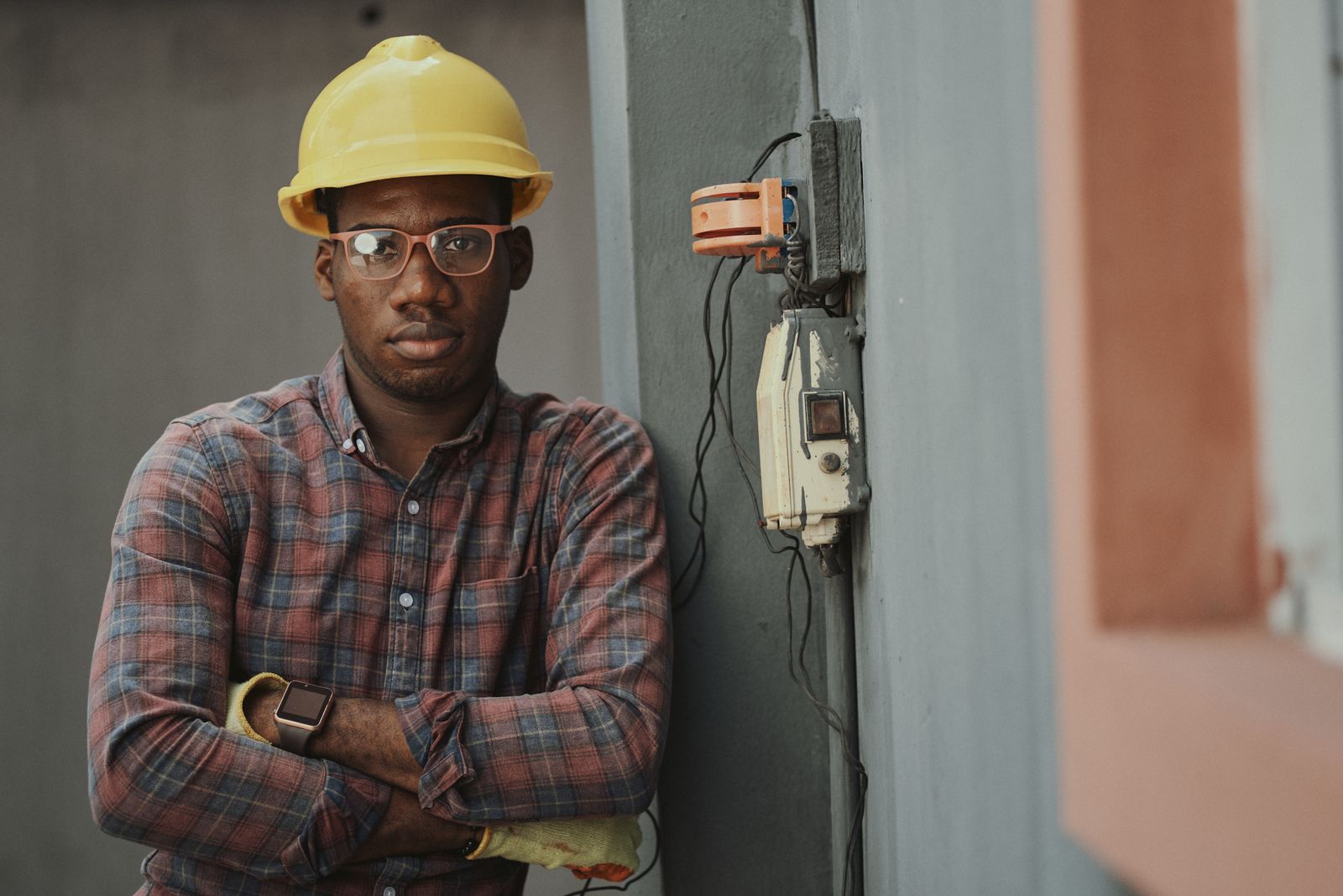 Licensed electrician in a yellow hard hat on a job site