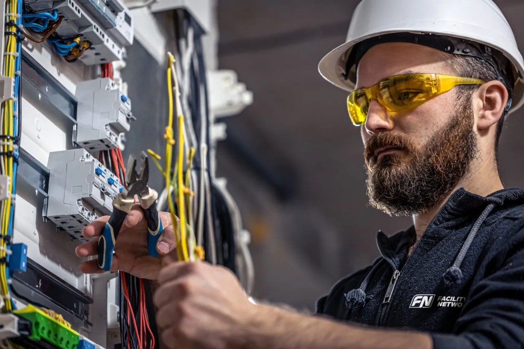 Licensed electrician working on a commercial electrical panel
