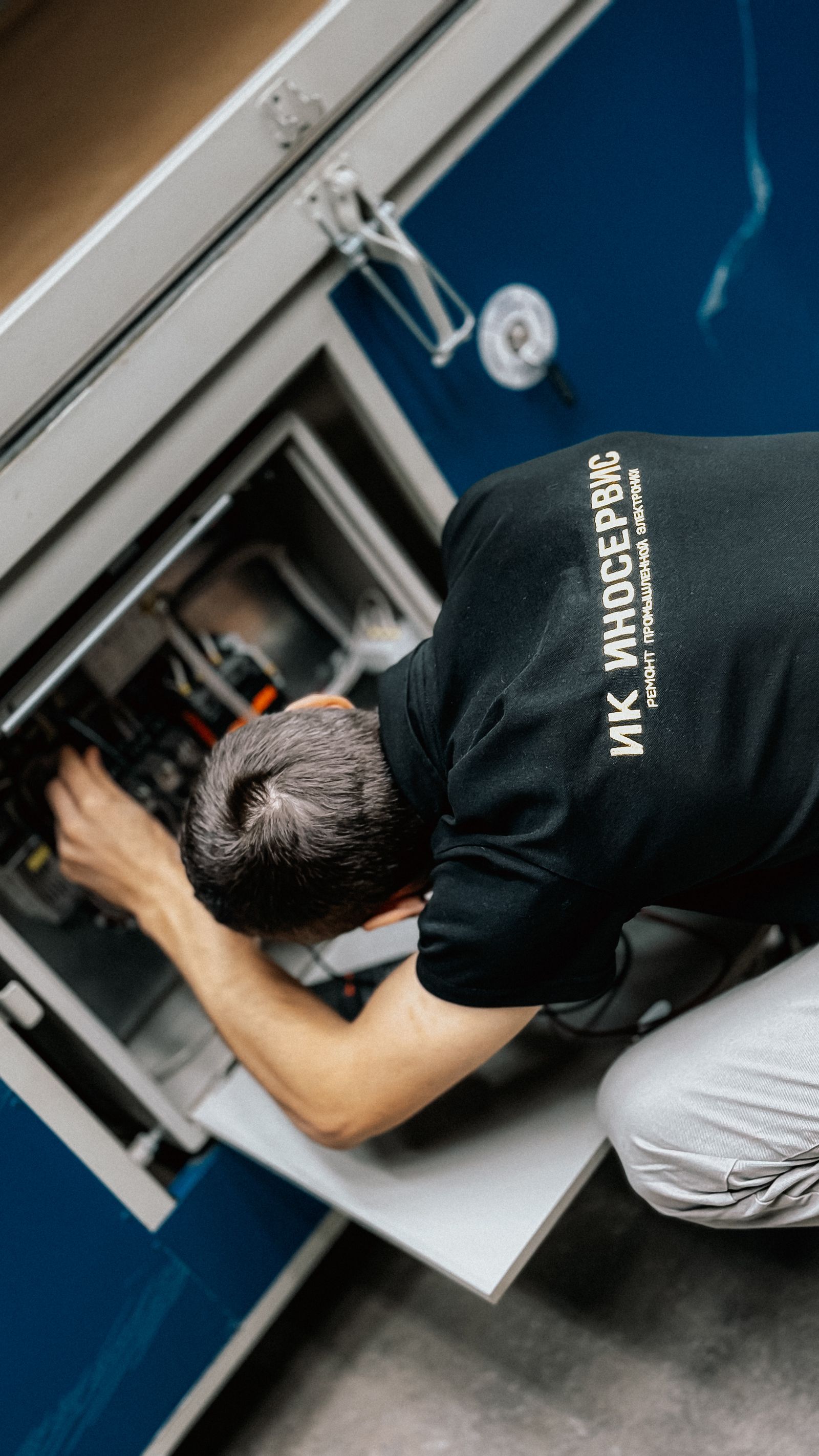 Industrial power technician wiring automated machinery control box